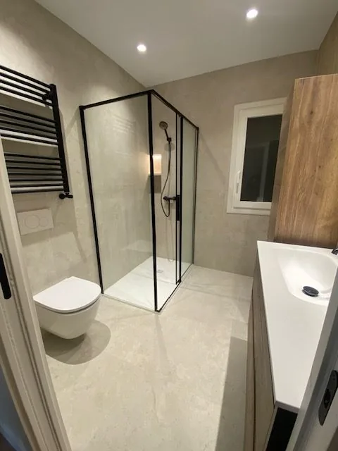 Baño con mampara y radiador negros