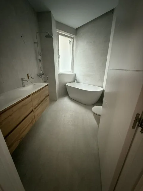 Baño con bañera exenta y mueble de madera
