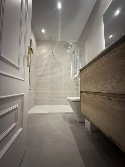 Recibidor con mueble de madera y luz indirecta
