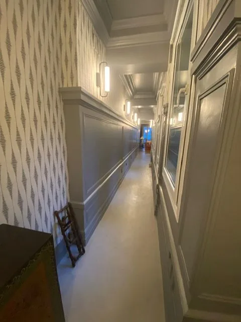 Pasillo con suelo de microcemento y papel pintado