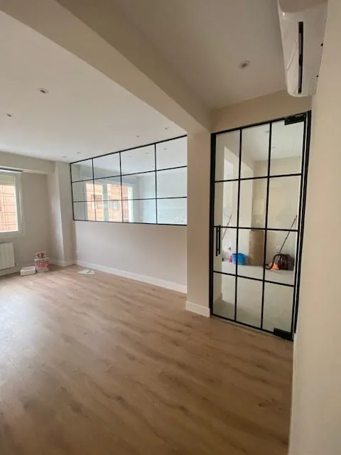 Salón diáfano con puerta acristalada de estilo industrial